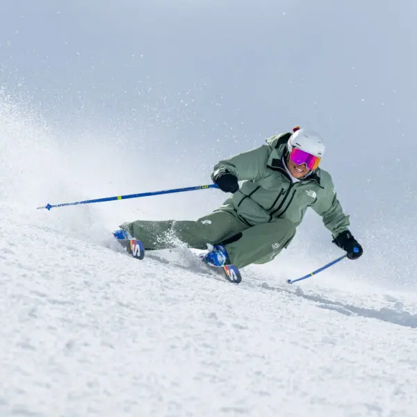 Skier carving through fresh snow.