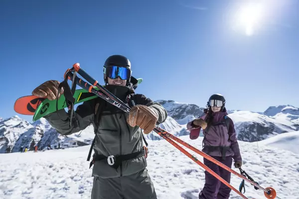 man and woman holding ski gear and smiling