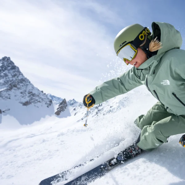 Skier navigating snowy mountain landscape.