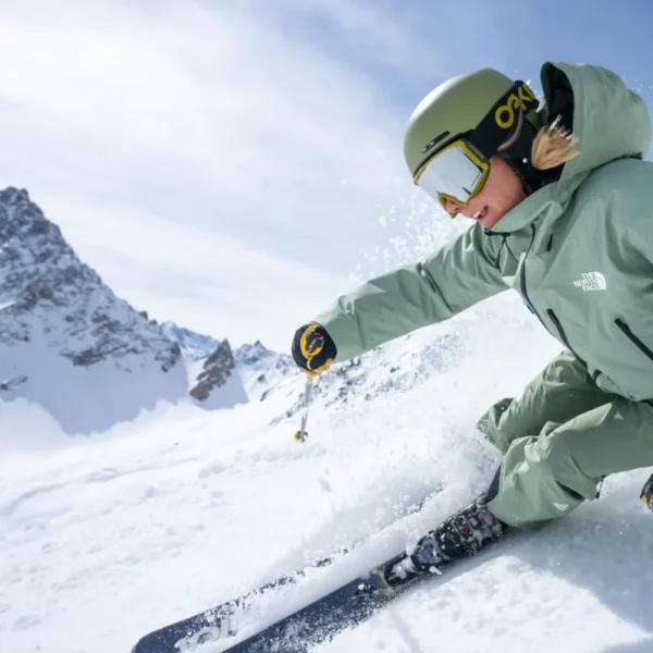 Skier navigating snowy mountain landscape.