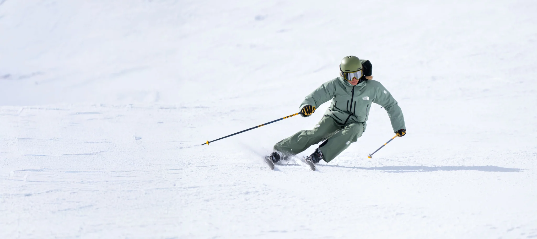 Skier carving through fresh snow.