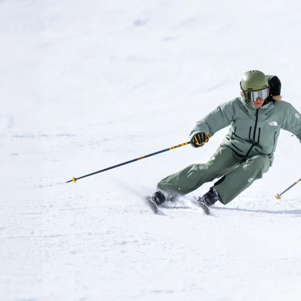 Skier carving through fresh snow.