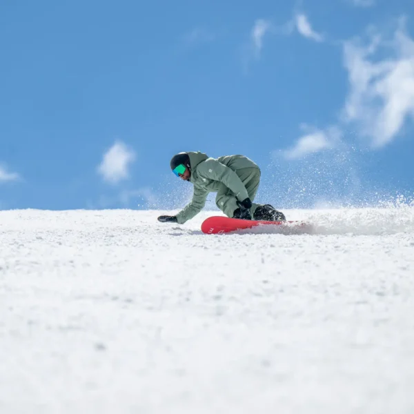 Snowboarder carving through fresh snow.