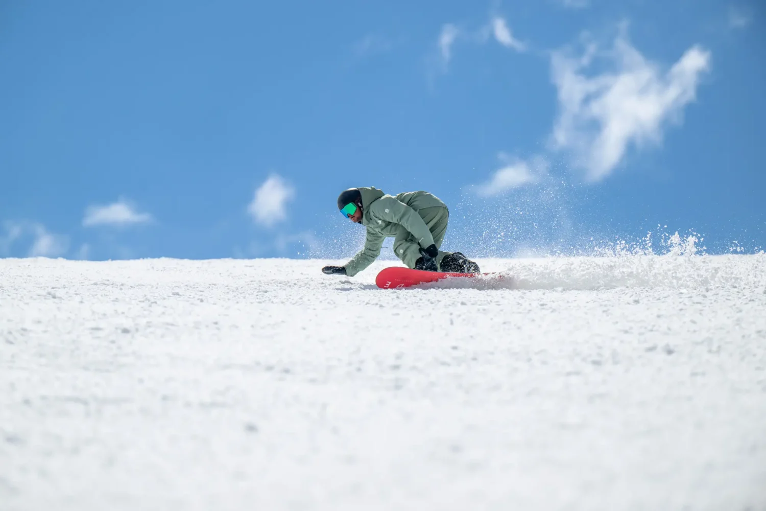 Snowboarder carving through fresh snow.