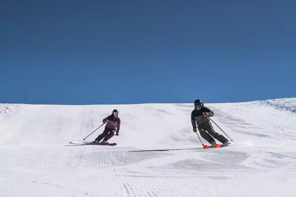 Mann und Frau fahren einen Hang hinunter