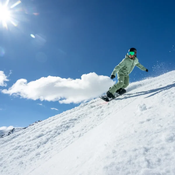 Snowboarder carving through fresh snow.
