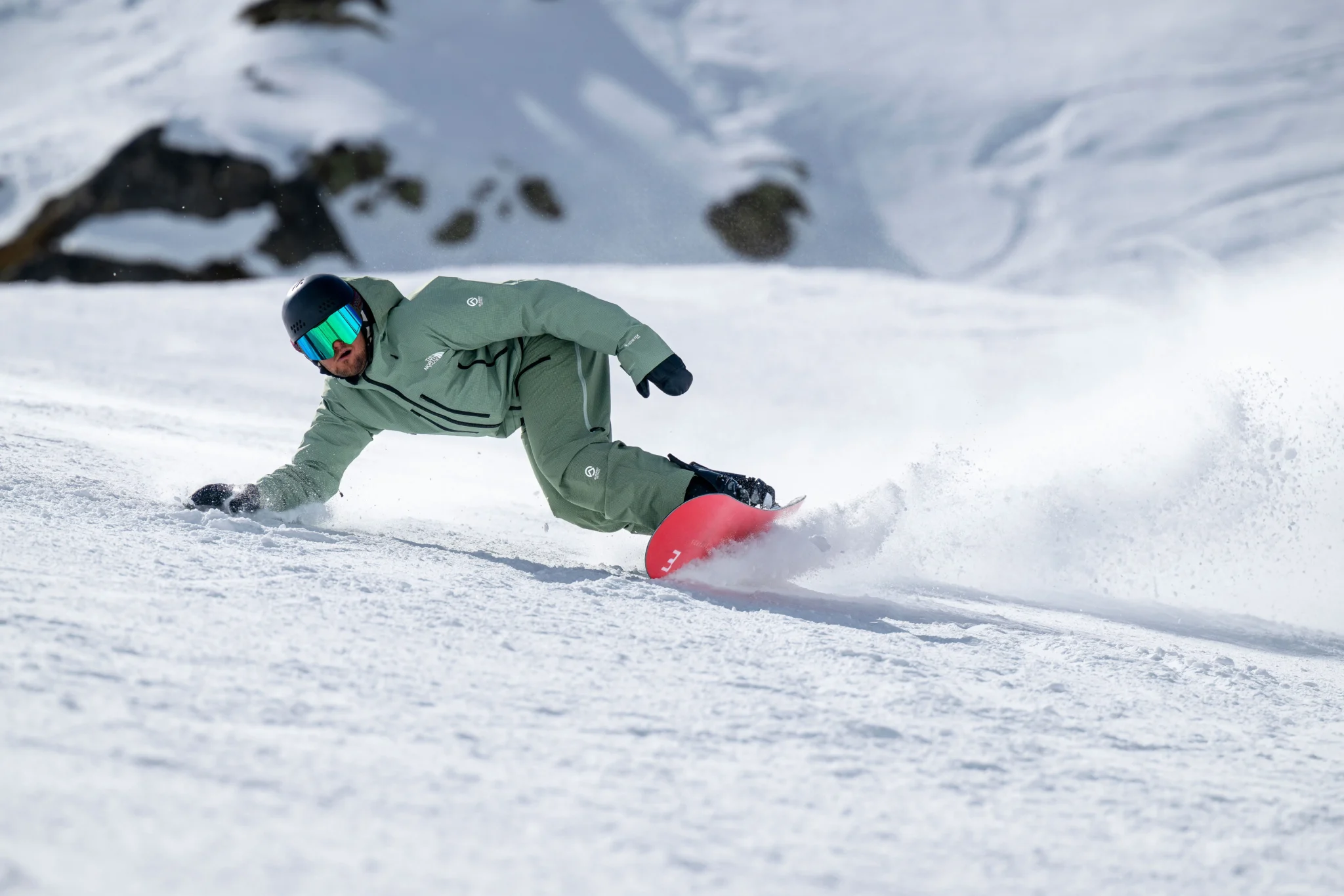 Snowboarder carving through fresh snow.