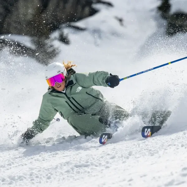 Skier carving through fresh snow.