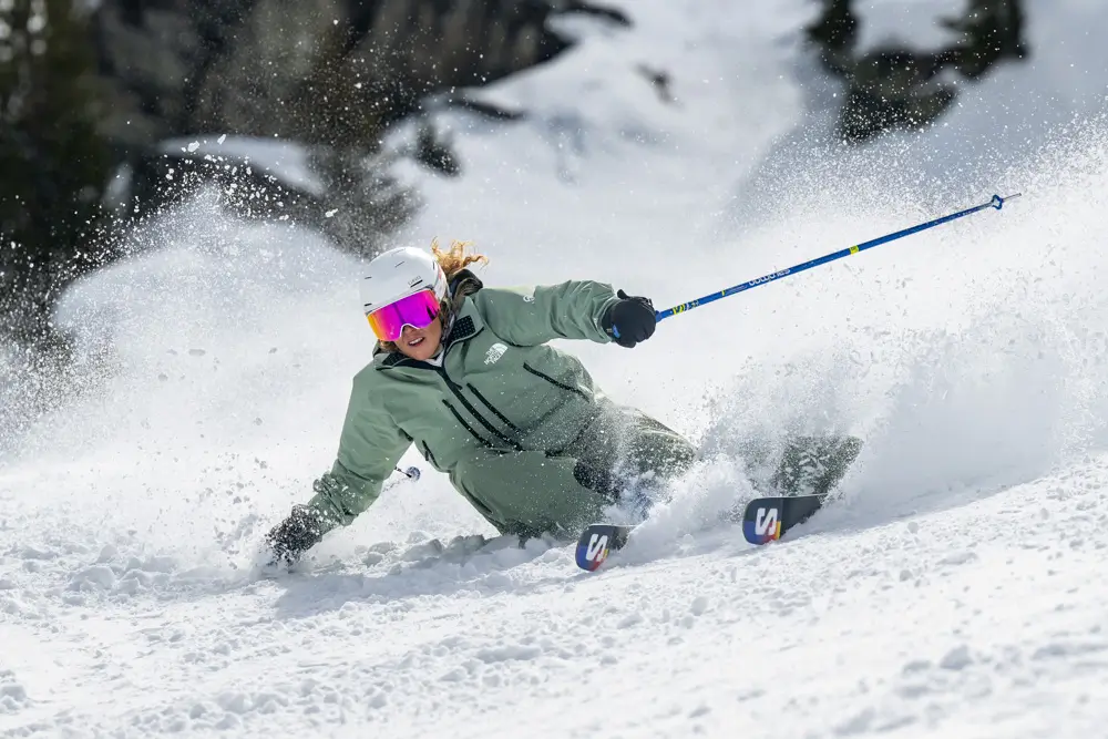 Skier carving through fresh snow.