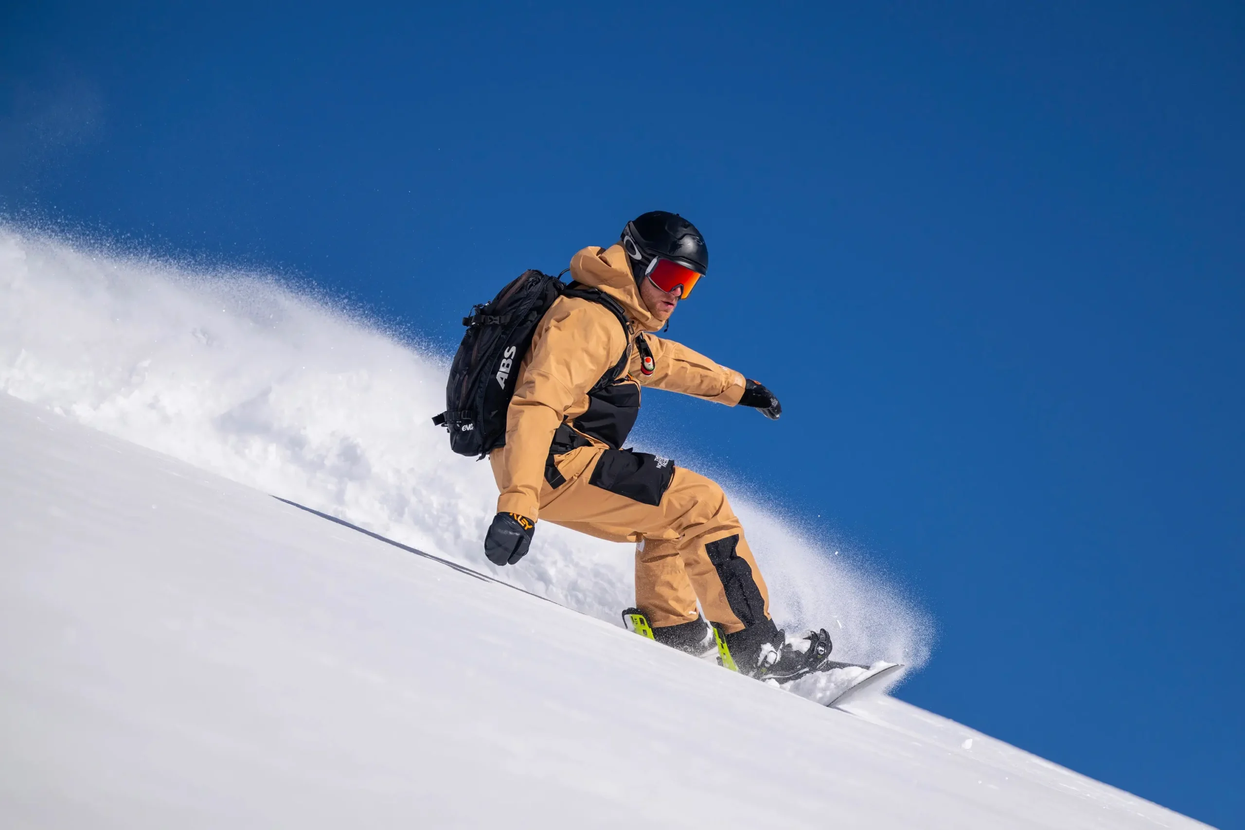 Ein Snowboardlehrer, der eine Kurve abseits der Piste fährt