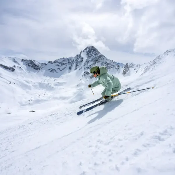 Skier carving fast turn down steep powder slope in the Alps