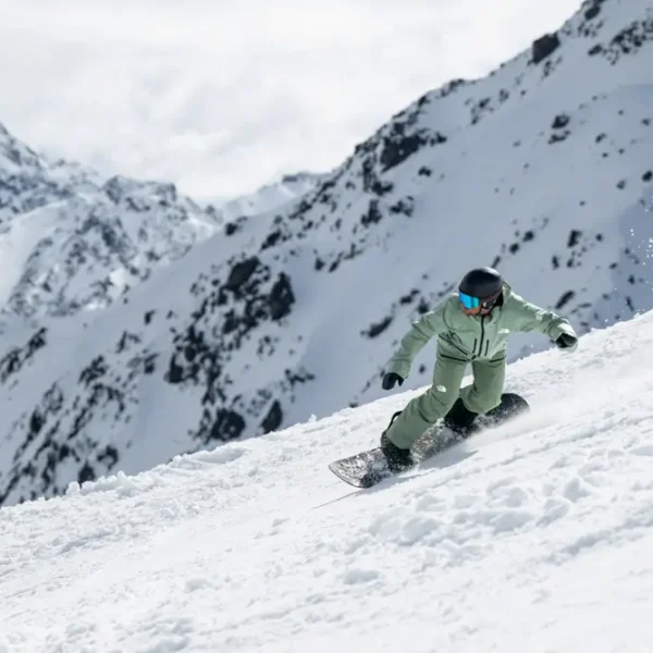 Snowboarder carving through snowy mountain
