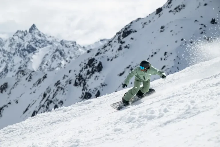 Snowboarder carving through snowy mountain