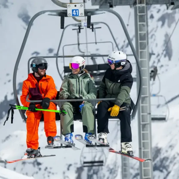 Three skiers on a chairlift.