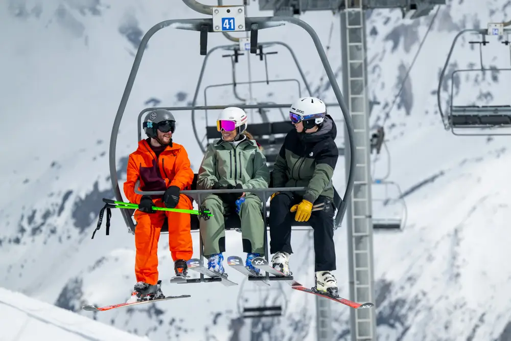 Three skiers on a chairlift.
