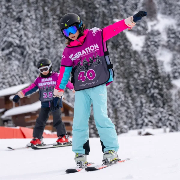 Children learning to ski in New Generation Ski School race bibs on snowy slope