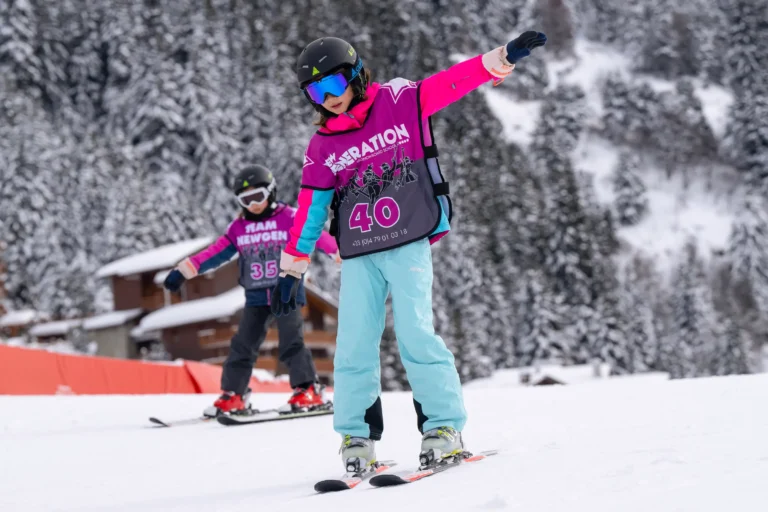 Children learning to ski in New Generation Ski School race bibs on snowy slope