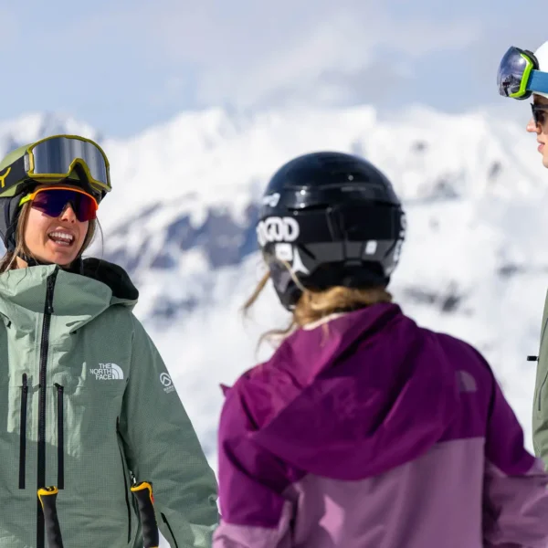A ski instructor delivering a group ski lesson in verbier. The participants discussing ideas on a snowy mountain background