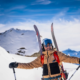 A ski instructor with his arms open, smiling in a welcoming way