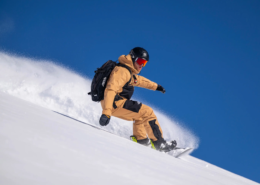 A snowboard instructor making a turn off-piste