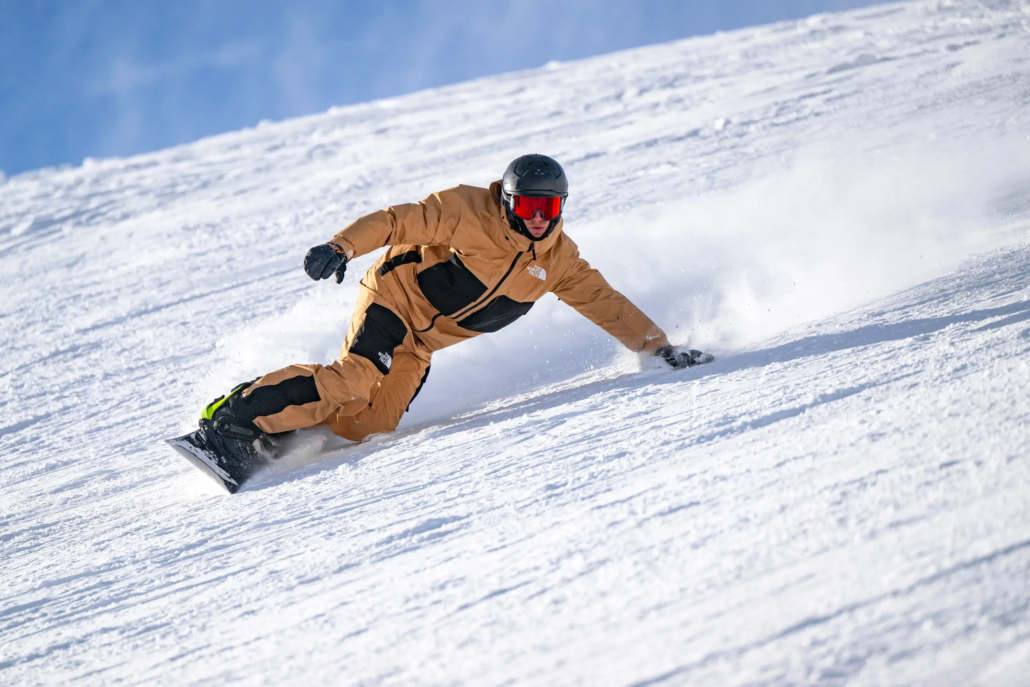 A snowboard instructor making a carved turn