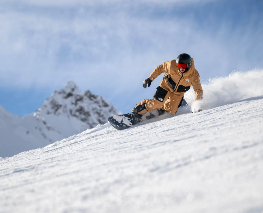 A snowboarder making a carved turn in Verbier