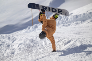 An instructor demonstrating how to do a trick in a private snowboard lesson