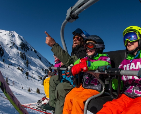 CHildren on a chairlift with a ski instructor