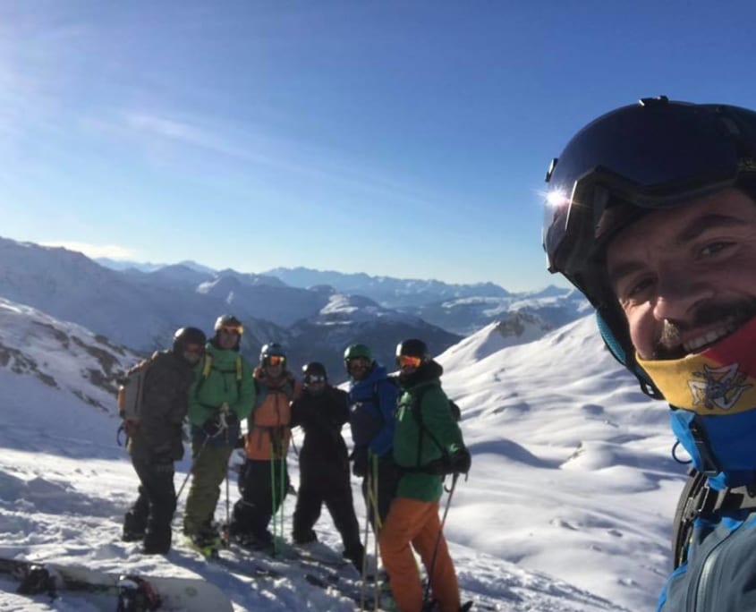 Ski Instructor with clients at the top of a mountain