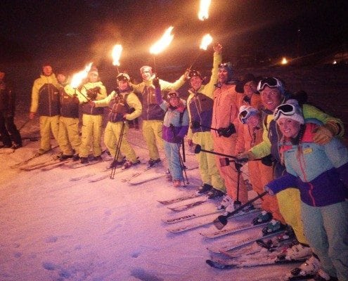 Ski instructors carrying torches in Courchevel