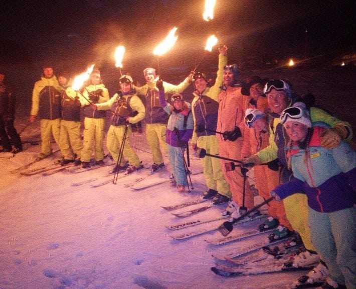 Ski instructors carrying torches in Courchevel