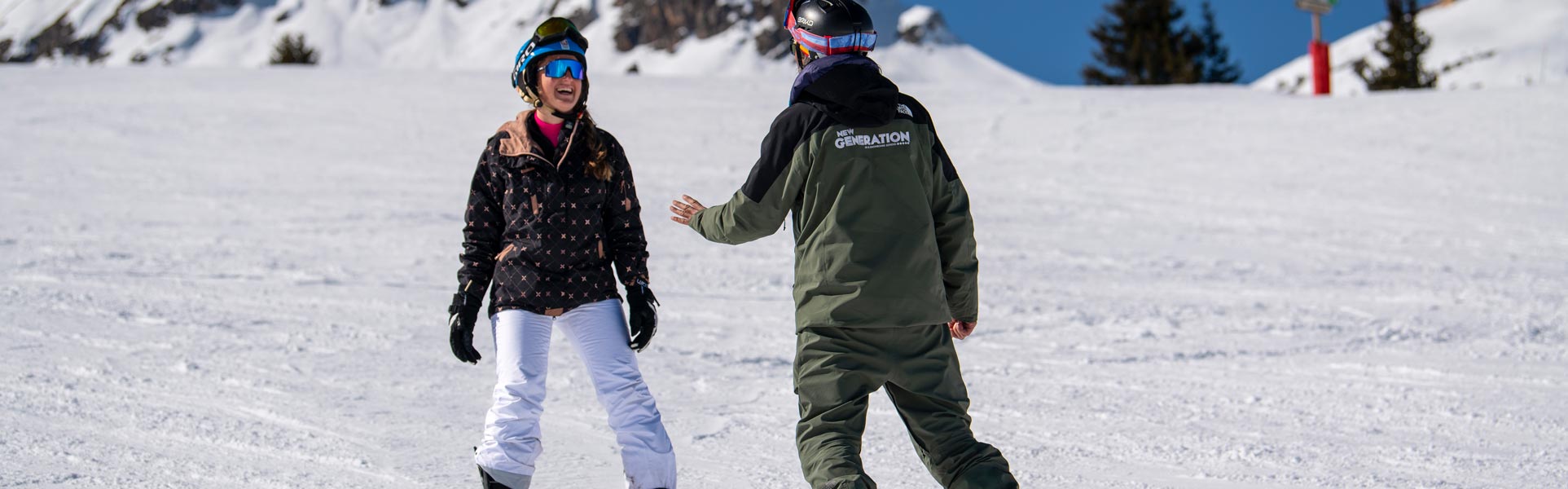 A snowboarder laughing at something there snowboard instructor has said during a private snowboard lesson