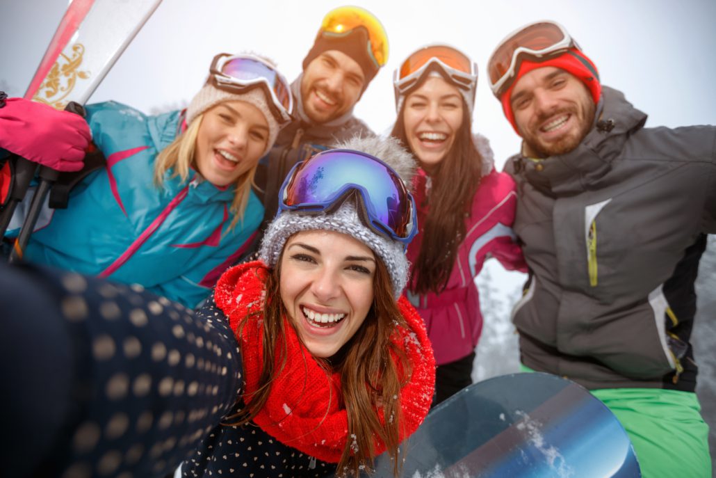 Group of friends having fun on the snow and making selfie