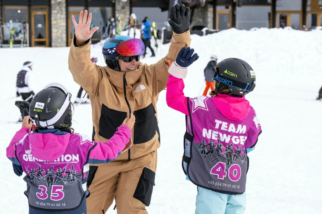 2 children getting a high five in ski school