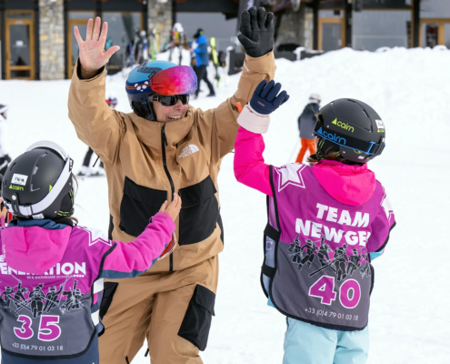 2 children getting a high five in ski school